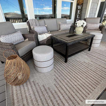 Outdoor patio scene with gray wicker furniture on the cream and tan striped Winmalee Area Rug. Roomscene-Rectangle