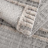 Close-up of the Amaga High-Low Rustic Rug showing its cream and gray geometric pattern and high-low textured design. Fold