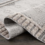 Close-up of the Amaga High-Low Rustic Rug showing its geometric pattern, charcoal, cream, and gray colors, and textured design. Fold