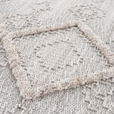 Close up of the Amaga High-Low Rustic Rug. Cream, light beige, and gray geometric pattern with high-low texture. Texture