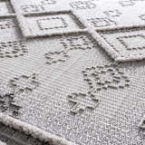 Close-up of the Amaga High-Low Rustic Rug showing its geometric design, plush texture, and charcoal and cream color palette. Texture
