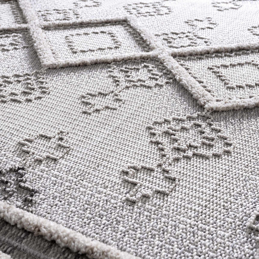 Close-up of the Amaga High-Low Rustic Rug showing its geometric design, plush texture, and charcoal and cream color palette. Texture
