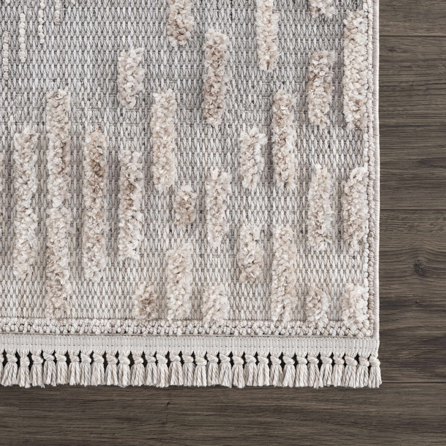 Close-up of the Poydras High-Low Rustic Rug. Features a light beige high-low pile and knotted fringe detail. Swatch