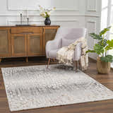 Living room scene with a Poydras High-Low Rustic Rug in charcoal, gray and beige, styled with a chair and wood cabinet. Roomscene-Rectangle