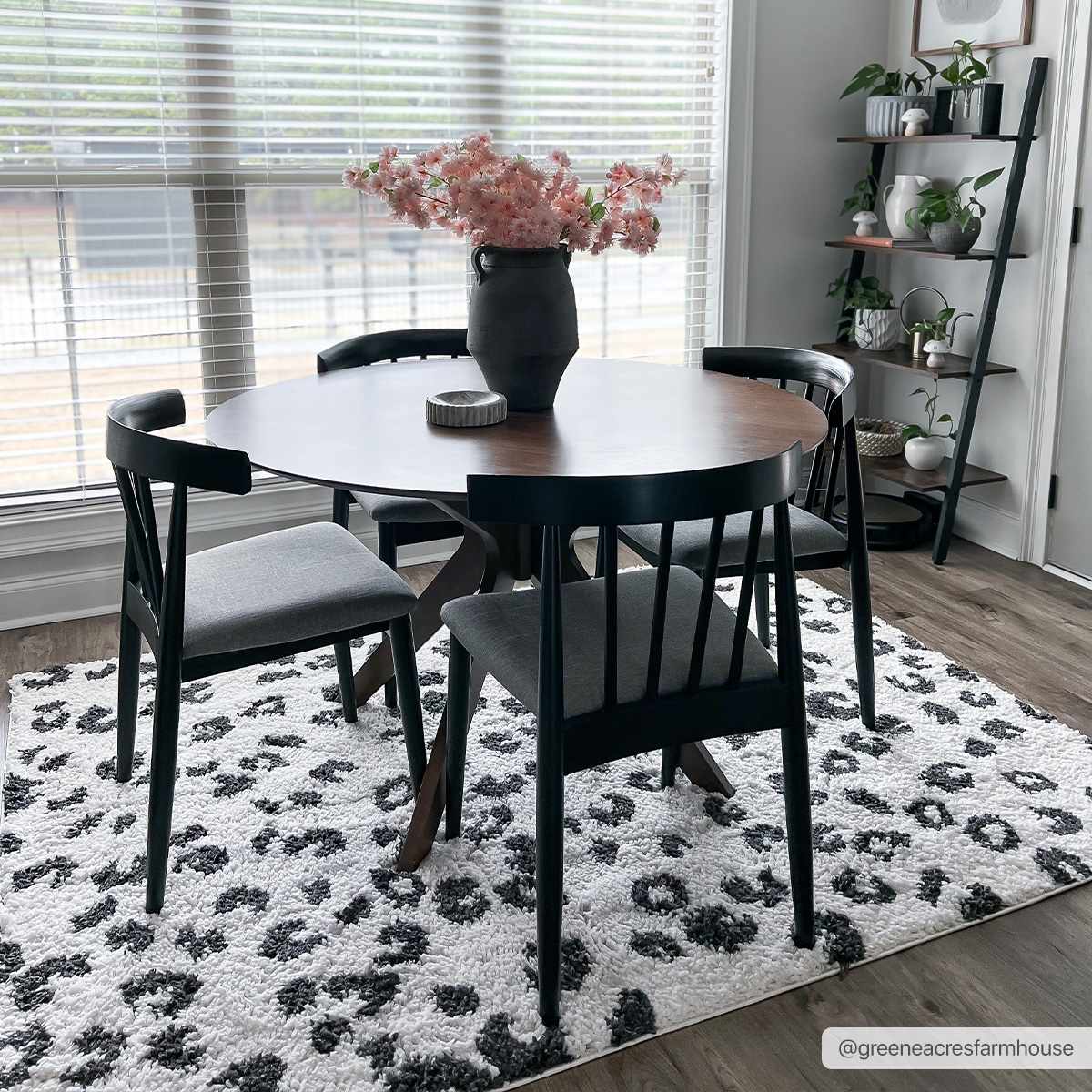 Dining room scene with a round table on a Zhen Black Spots Leopard Rug. Black chairs and a decorative ladder shelf. Roomscene-Rectangle