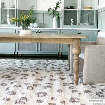 Dining room with a Zhen Pink Spots Leopard Rug, light wood table, and pale green cabinets. Roomscene-Rectangle