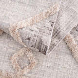 Close-up of the Serkomen High-Low Area Rug showing its textured weave, geometric pattern, and high-pile accents. Fold