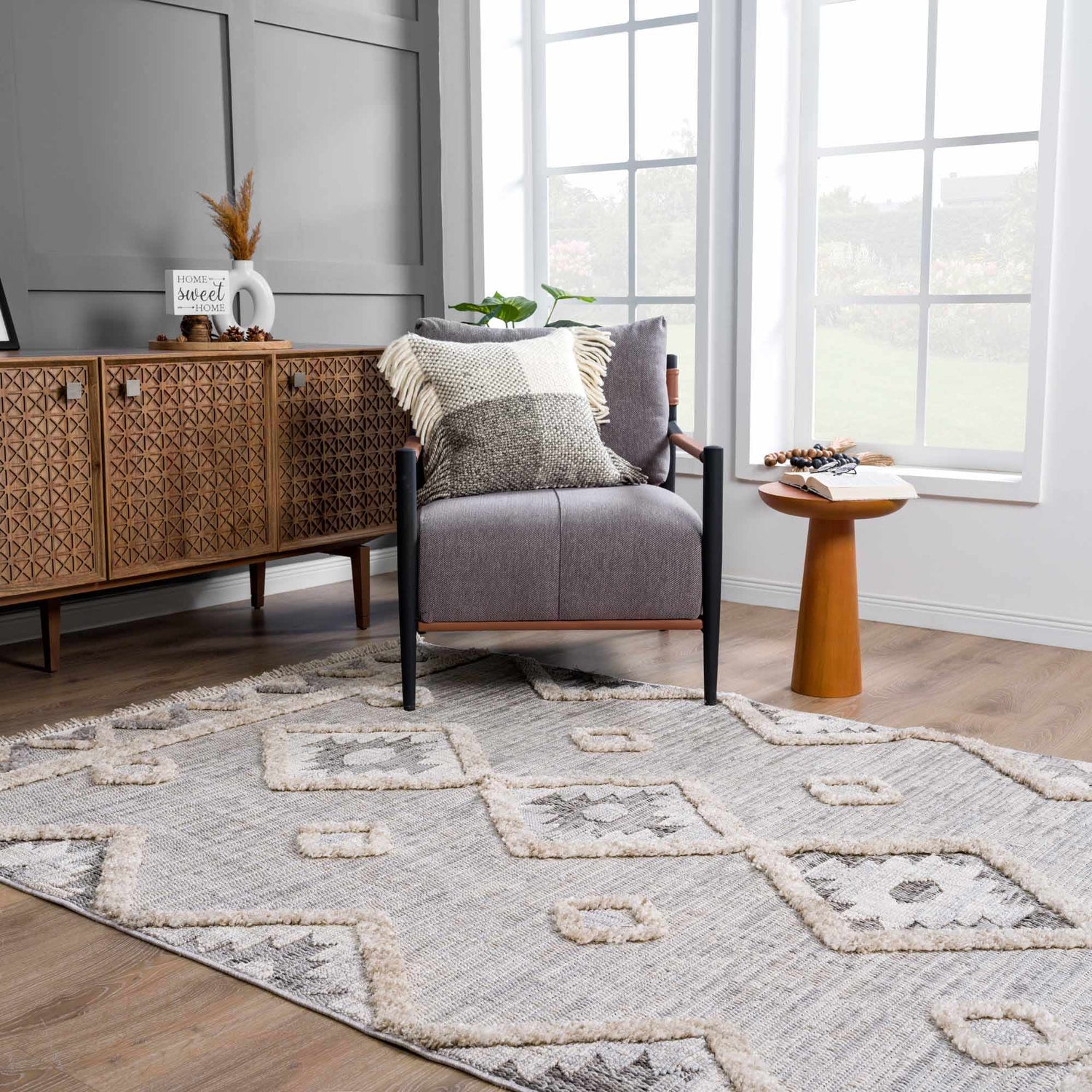 Living room scene with Serkomen High-Low Area Rug, gray chair, wood cabinet, and side table near window. Roomscene-Rectangle