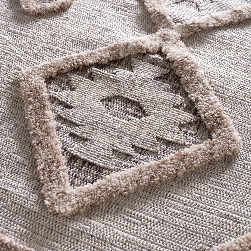 Close-up of the Serkomen High-Low Area Rug showing the textured geometric pattern and raised, soft pile details. Texture