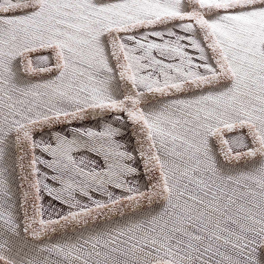 Close-up of Serkomen High-Low Area Rug. Beige polyester rug with geometric square pattern and textured, high-pile details. Texture