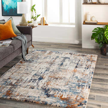 Living room scene with gray sofa and Abaca Abstract Thick Rug in blue, brown, and cream on wood floors. Modern style. Roomscene-Rectangle
