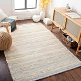 Living room scene with Abucay Jute Rug in cream and charcoal, styled with a wooden cabinet and bench. Roomscene-Rectangle