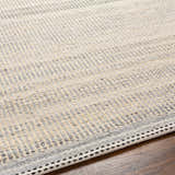 Close-up of the hand woven Abucay Jute Rug. Charcoal, cream, and light beige jute and wool fibers create a textured look. Texture