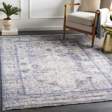 Living room scene featuring the Accokeek Luxe Area Rug. Denim, beige, and navy vintage style rug under chair and side table. Roomscene-Rectangle