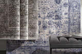 Close-up of the Accokeek Luxe Area Rug in denim, light beige, and navy, styled with a gray bench and open book. Styleshot