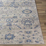 Close-up of the Adairsville Blue Floral Area Carpet, featuring a denim, gray, and ivory traditional floral pattern. Front