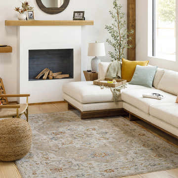 Living room scene with a Luxe Adana Oushak Rug, cream sectional sofa, fireplace, and natural light. Country Farmhouse style. Roomscene-Rectangle