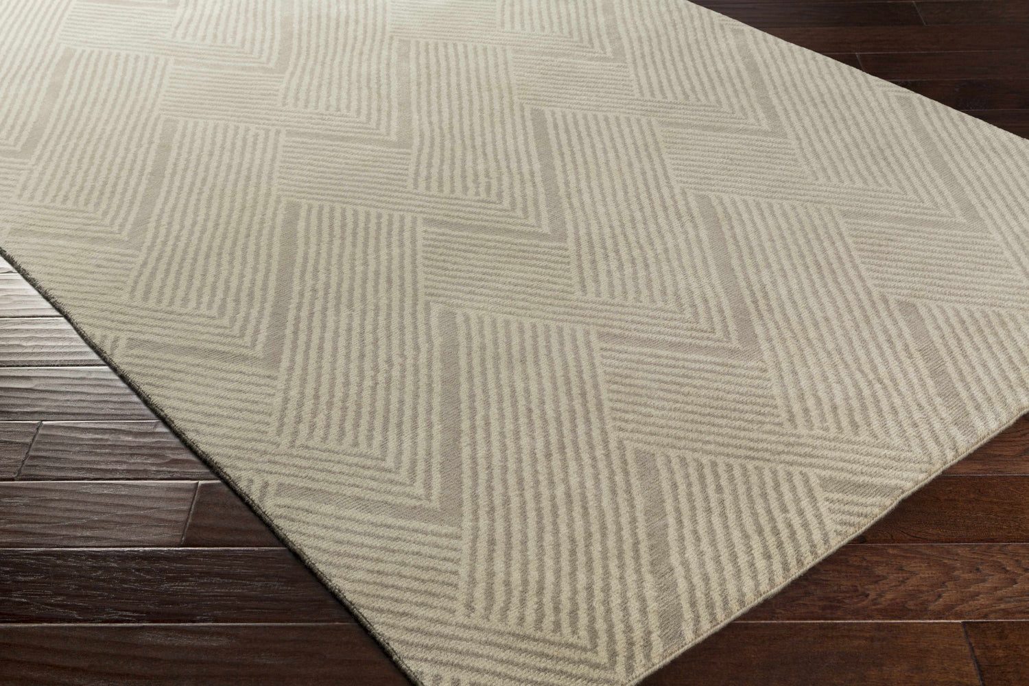 Close-up of the hand-knotted Adelanto Area Rug. Brown and taupe wool rug features a contemporary geometric pattern. Corner