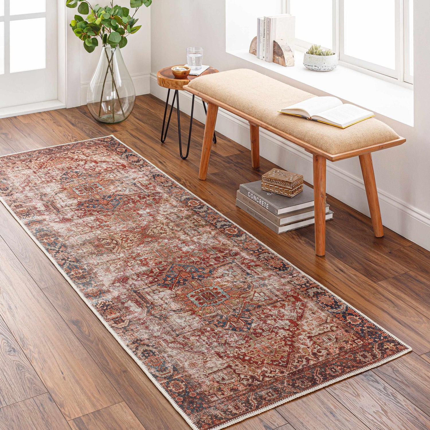Entryway scene with a burgundy and navy Adtugan Vintage Flat Pile Washable Rug on a wood floor. Bench, side table, and plants. Roomscene-Runner