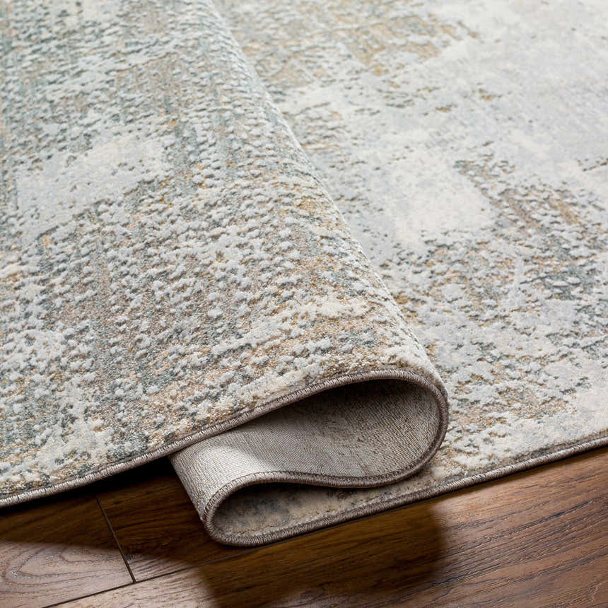 Close-up of the Adwoa Boutique Rug showing its cloud gray, nutmeg, and light gray contemporary design and machine-woven texture. Fold