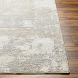 Close-up of Adwoa Boutique Rug showing a contemporary abstract pattern in cloud gray, dark gray, and nutmeg on wood floors. Front