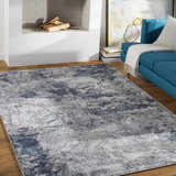 Living room scene with a blue sofa and Ainslie Gray Marble Rug in charcoal, denim, and white. Roomscene-Rectangle