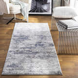 Living room scene with a gray and blue Ainslie Gray Marble Rug, modern chair, and metal bench. Roomscene-Runner