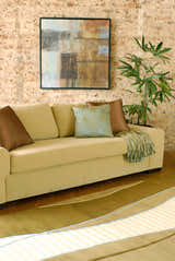Living room scene with a sage sofa, brick wall, and Alanreed Brown Premium Wool Area Rug. Roomscene-Rectangle