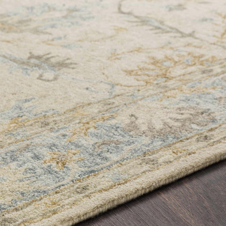 Close up of the hand tufted Albert Luxury Wool Rug showing beige, ice blue, and wheat colors. Texture