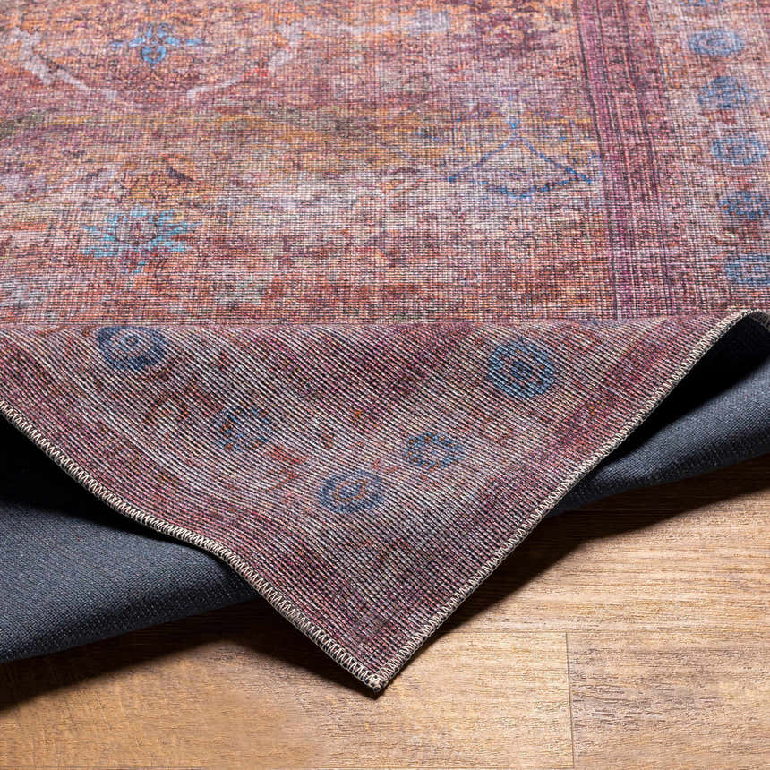 Close-up of Alcoy Washable Area Rug showing its traditional, multi-brown, dark purple, and pale pink oriental pattern. Fold