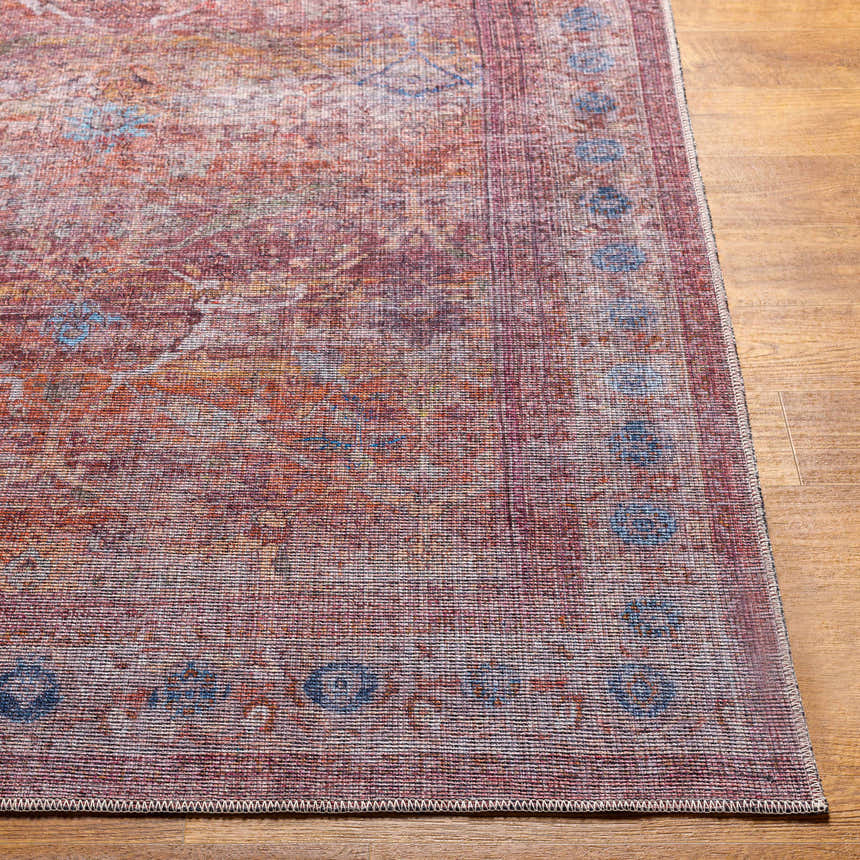 Close-up of the Alcoy Washable Area Rug showcasing its dark purple, brown, and pink oriental design and machine woven texture. Front