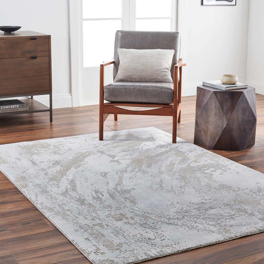 Living room scene with a gray Ambra Thick Luxe Boutique Rug, gray chair, wood accents, and light walls. Roomscene-Rectangle