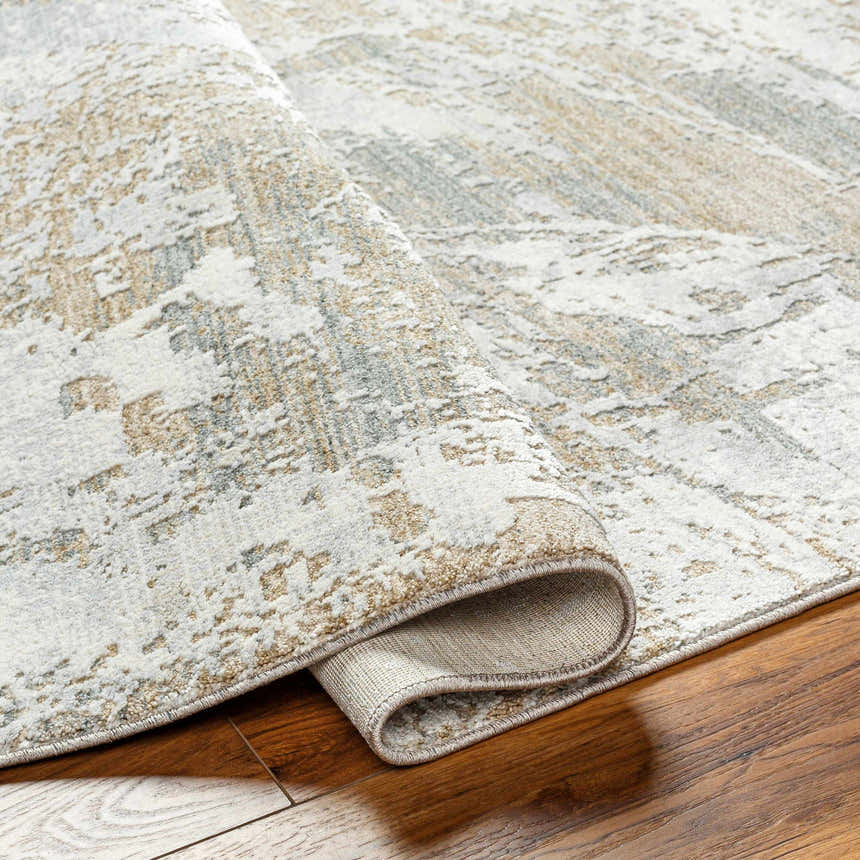 Close-up of the Ambra Thick Luxe Boutique Rug showing its gray, brown, and white contemporary pattern and plush texture. Fold