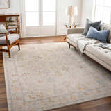 Living room scene with a neutral sofa and the Amina Oushak rug in amber, gray, and taupe tones. Farmhouse style. Roomscene-Rectangle