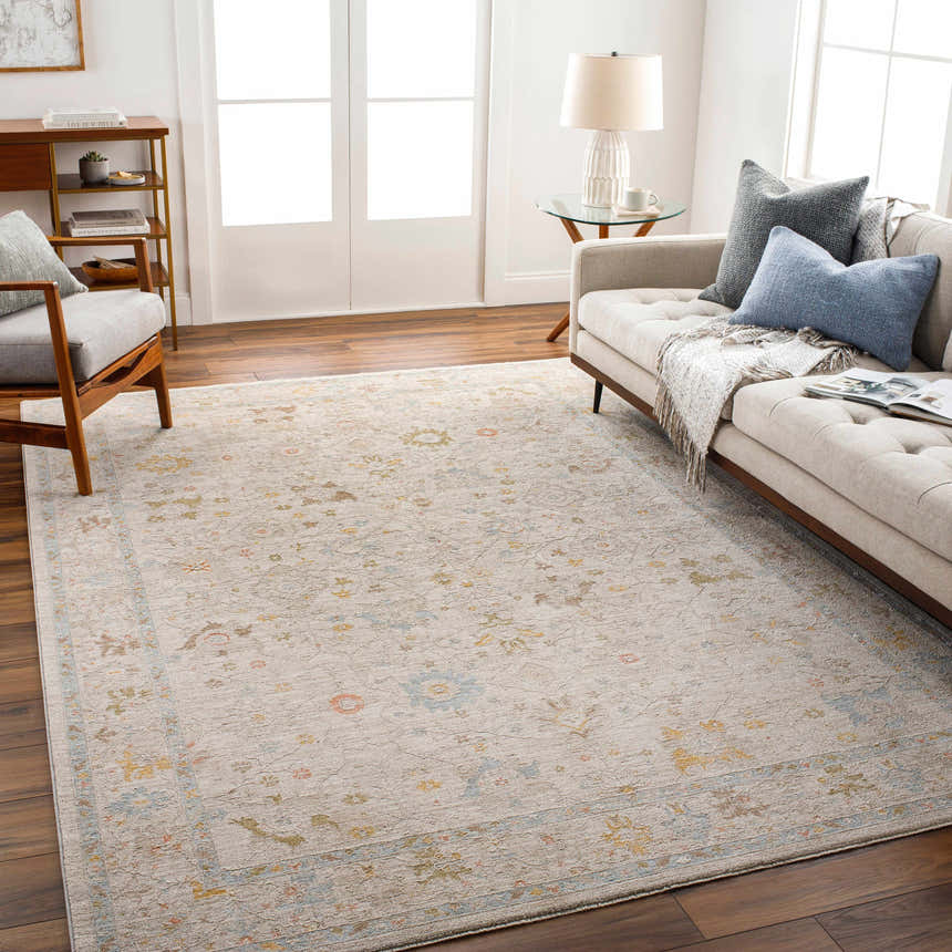 Living room scene with a neutral sofa and the Amina Oushak rug in amber, gray, and taupe tones. Farmhouse style. Roomscene-Rectangle