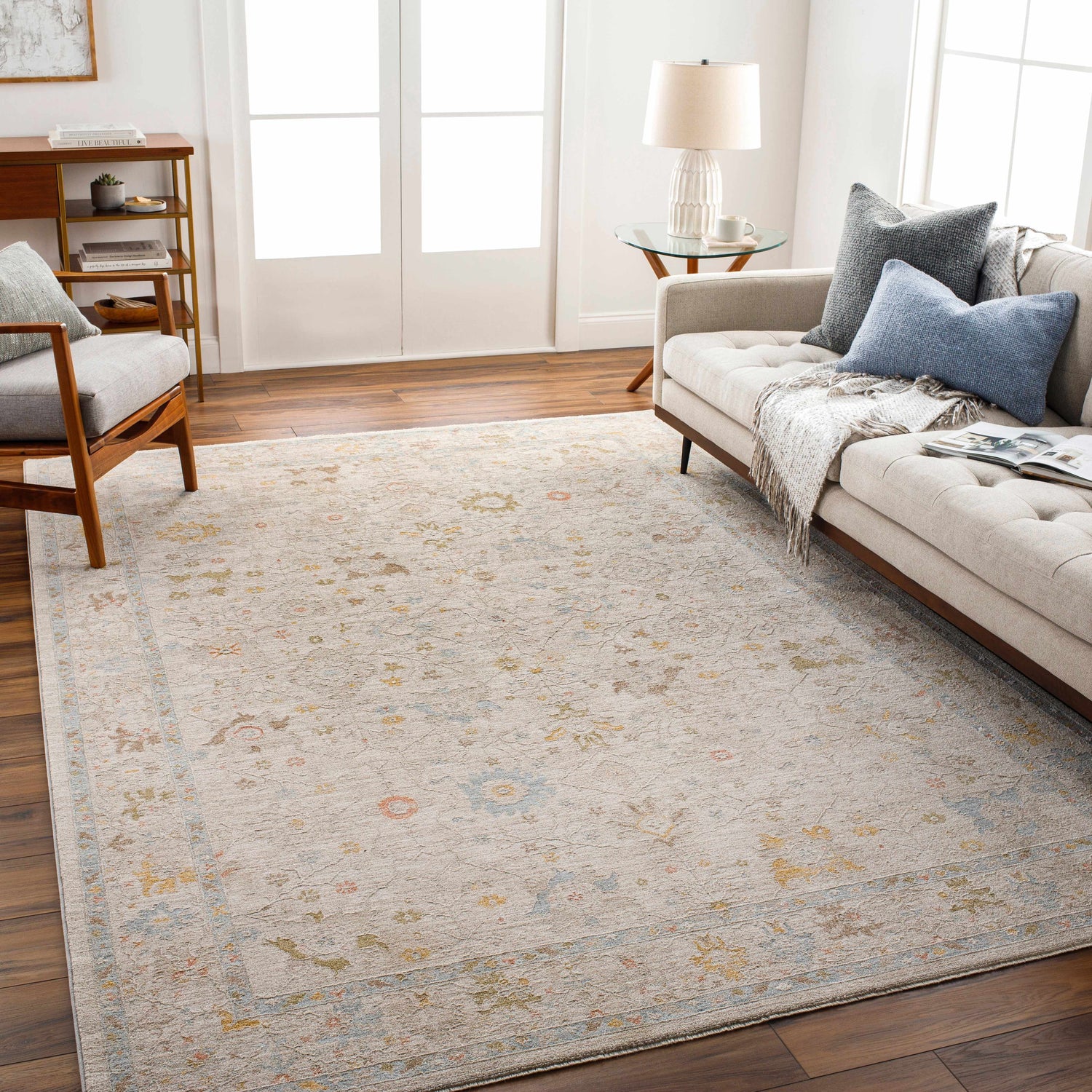 Living room scene with a neutral sofa and the Amina Oushak rug in amber, gray, and taupe tones. Farmhouse style. Roomscene-Rectangle