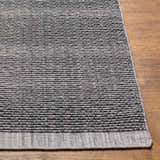 Close-up of the Yong Hand Loomed Gray Indoor Outdoor Rug showing its charcoal, gray, and light slate woven texture. Front