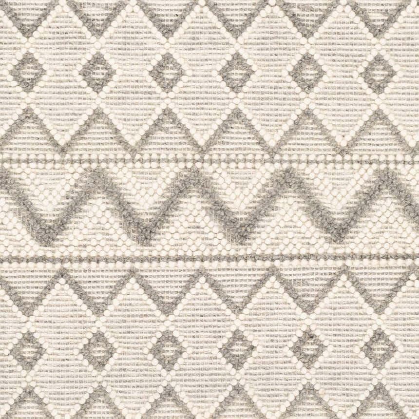 Close-up of the hand woven Whittington Gray&Cream Wool Rug, showcasing its geometric diamond pattern and textured wool material. Texture
