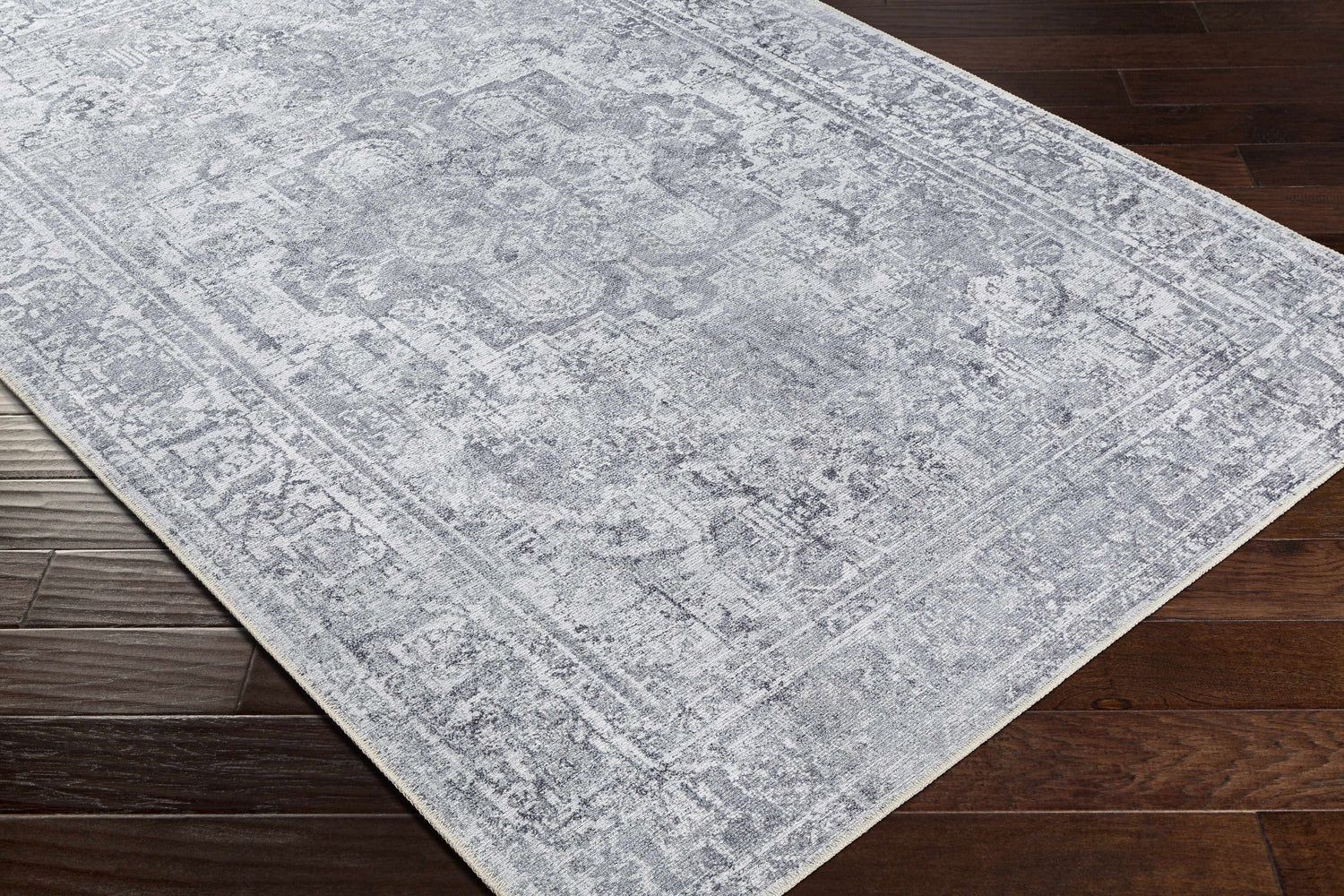 Close-up of the gray Aquino Washable Area Rug showing its traditional oriental pattern and soft texture. Corner