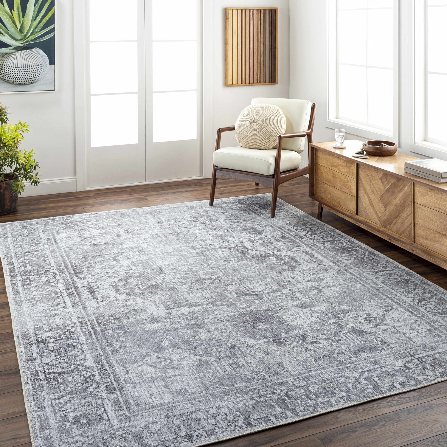 Living room scene with the gray Aquino Washable Area Rug, wood floors, chair, and console table. Bright, airy feel. Roomscene-Rectangle