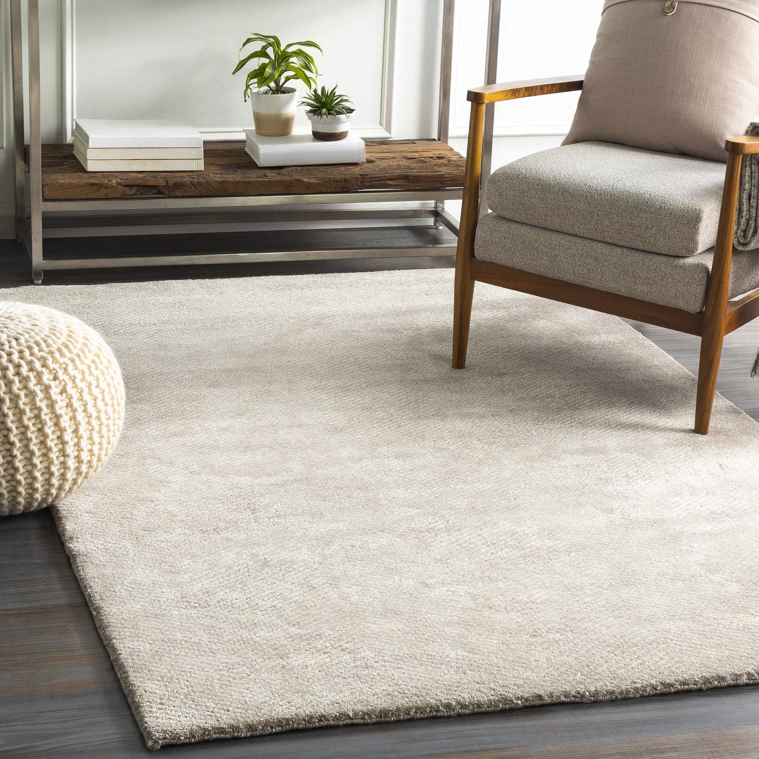 Living room scene with light gray Arkadelphia carpet, wood chair, and woven ottoman. Roomscene-Rectangle