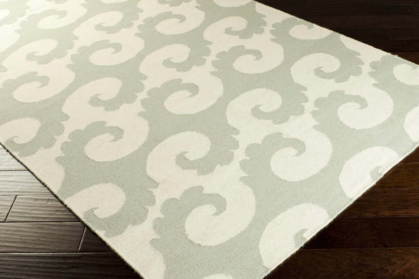 Close-up of the hand-woven Arkoma Area Rug. Dusty sage and ivory swirls pattern on wool rug. Contemporary style. Corner