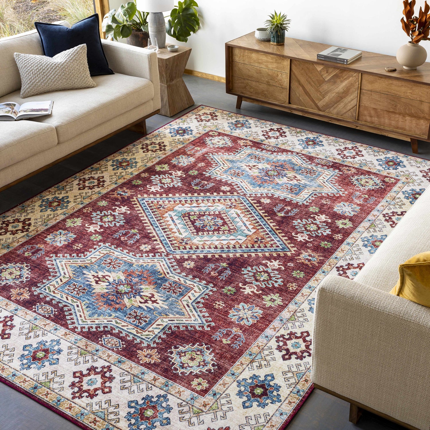Living room scene with Armadale Clearance Rug, featuring a bohemian, Southwestern-style rug with red, blue, and cream geometric patterns. Roomscene-Rectangle