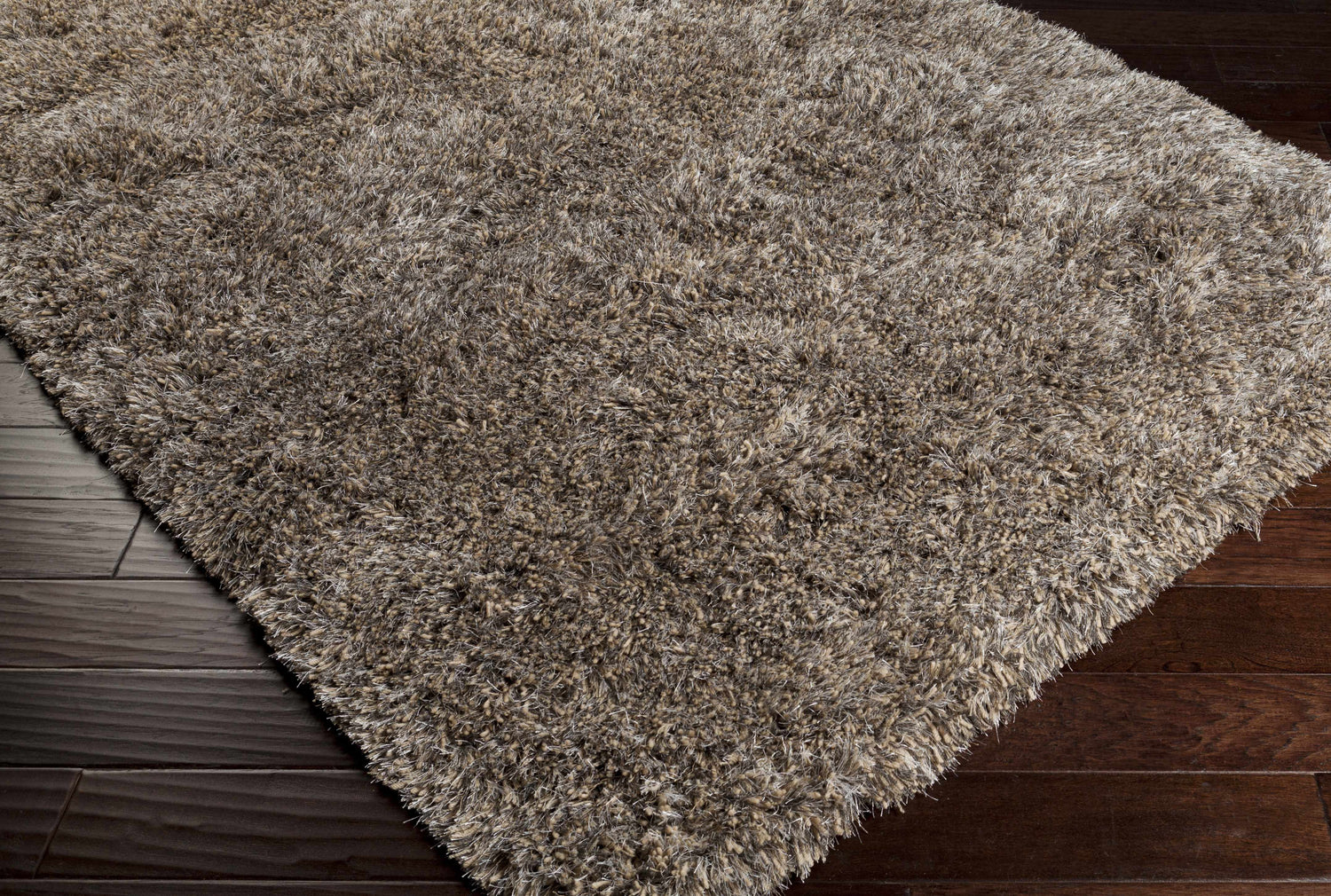 Close-up of the Ascot Area Rug in beige, charcoal, and olive, showing shag texture on dark wood floors. Corner