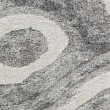 Close up of the Asfordby Gray Canyon Plush Rug, showing its charcoal, gray, and off-white shag texture. Swatch