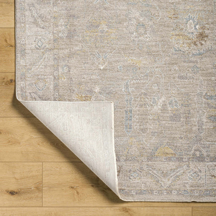 Close-up of Ashra Thick Luxe Area Rug in cloud gray with traditional design and soft texture on wood floor. Fold