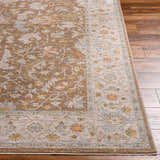 Close-up of the Atli Thick Luxe Area Rug in amber and brown with a traditional floral pattern on hardwood floors. Front