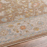Close-up of the Atli Thick Luxe Area Rug showing its traditional floral pattern in amber, brown, pink, and gray tones. Texture