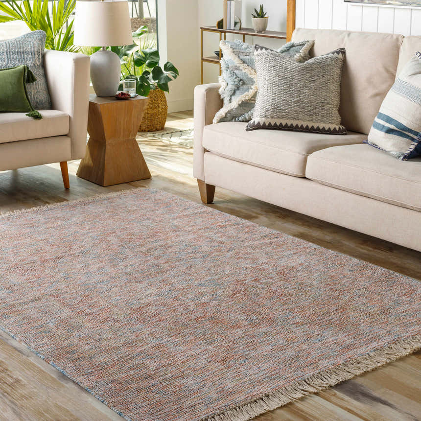 Living room scene with a fringed Atulayan Premium Rug in blue, burgundy, and coral tones, styled with a beige sofa and armchair. Roomscene-Rectangle