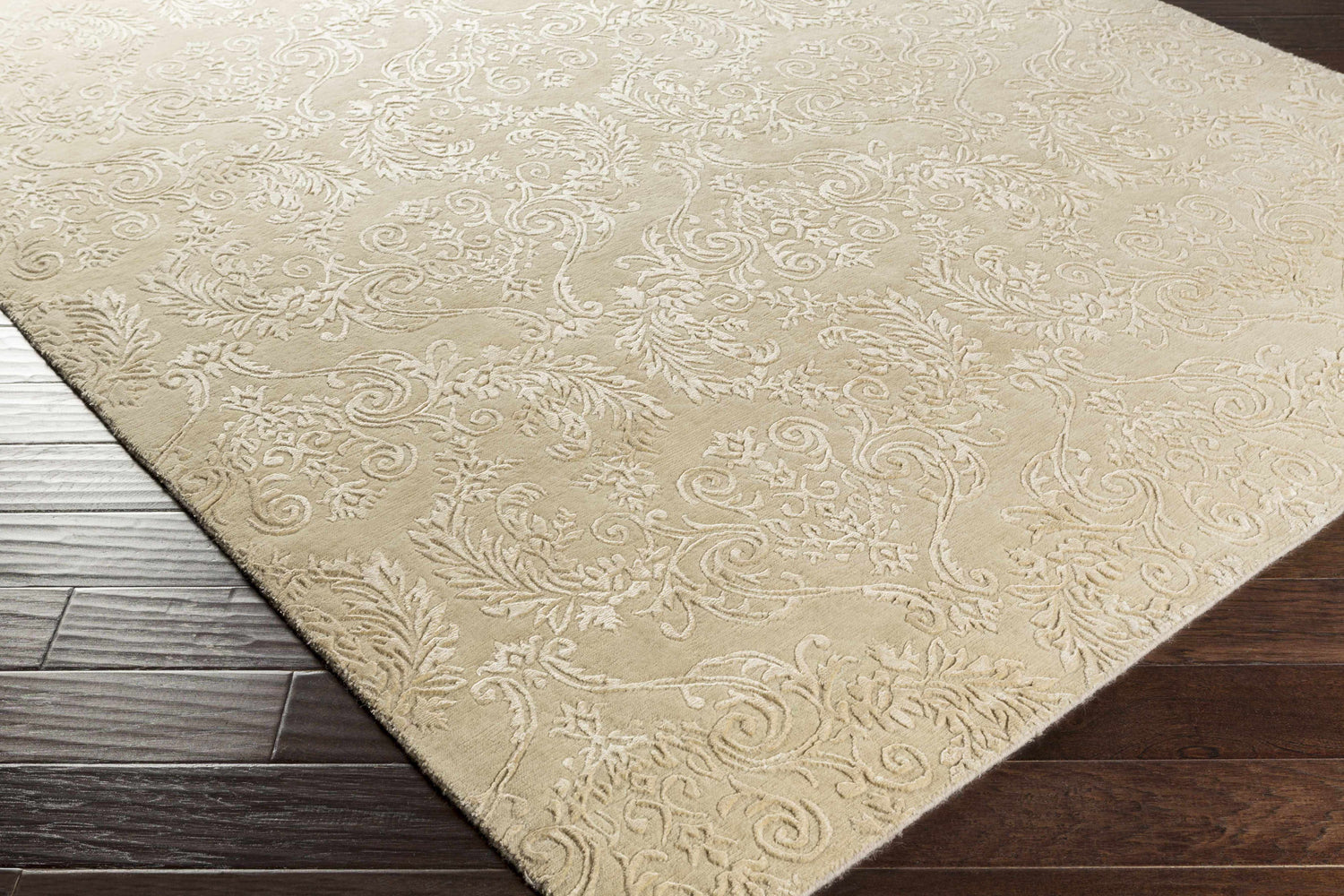 Close-up of the taupe Aubrey Area Rug showing its traditional floral design and hand-knotted texture. Corner